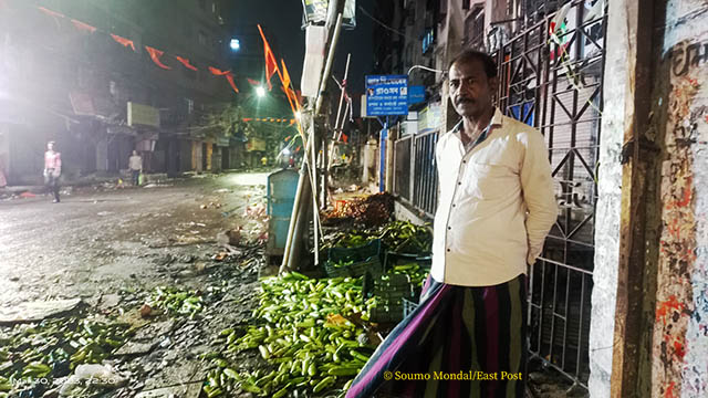 নষ্ট হয়ে যাওয়া সব্জির স্তুপের সামনে হায়দার আলী
